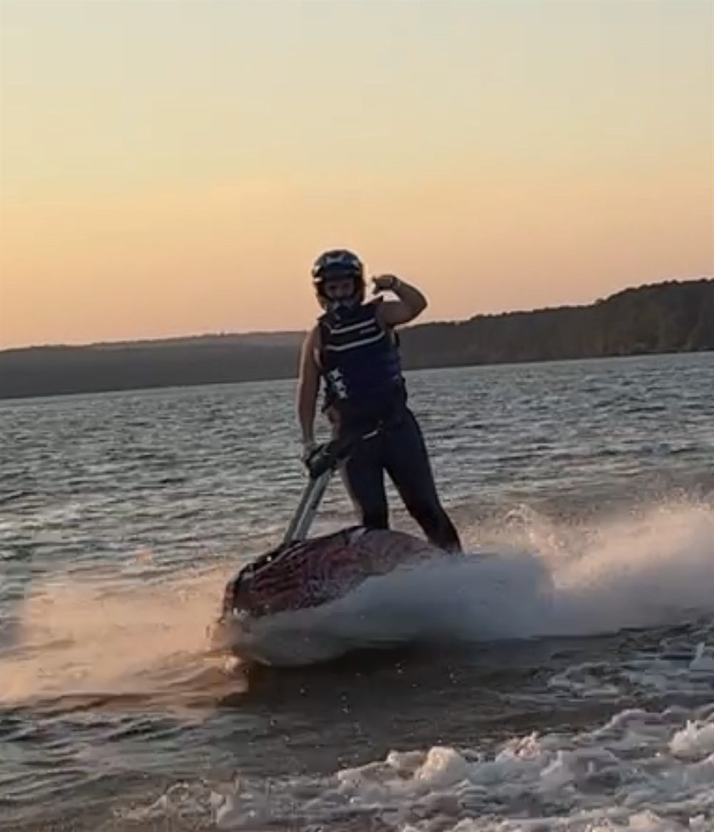 Jim Bisenius riding a stand-up jet ski at sunset